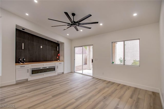 unfurnished living room featuring baseboards, light wood-type flooring, recessed lighting, a fireplace, and a ceiling fan