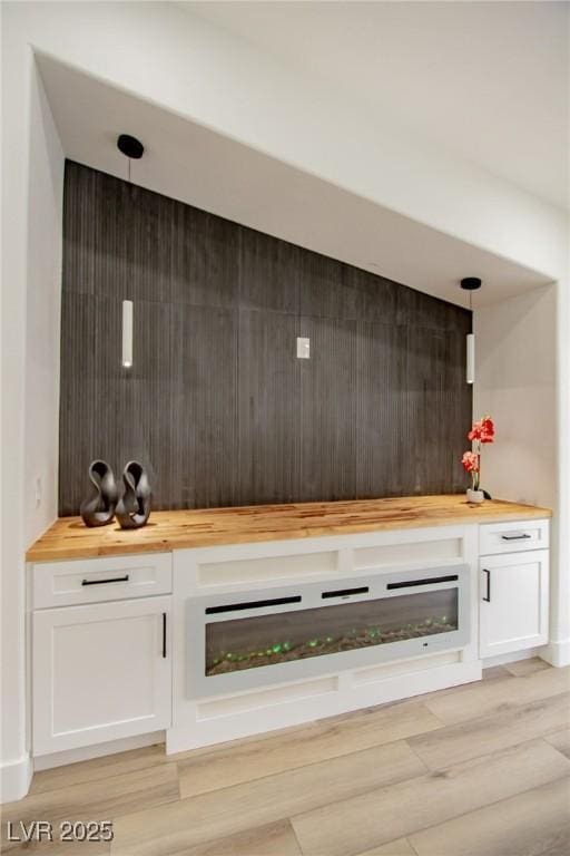 bar featuring hanging light fixtures and light wood finished floors