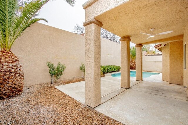 view of patio / terrace with a fenced backyard, an outdoor pool, and ceiling fan