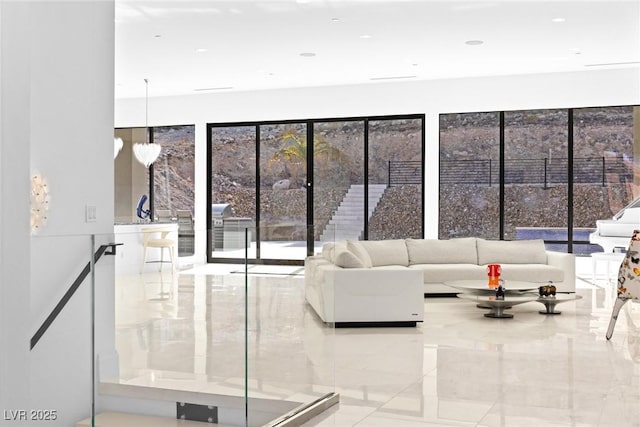 unfurnished living room featuring a chandelier and marble finish floor