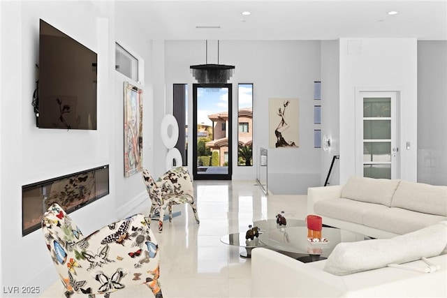 living area with recessed lighting and a glass covered fireplace