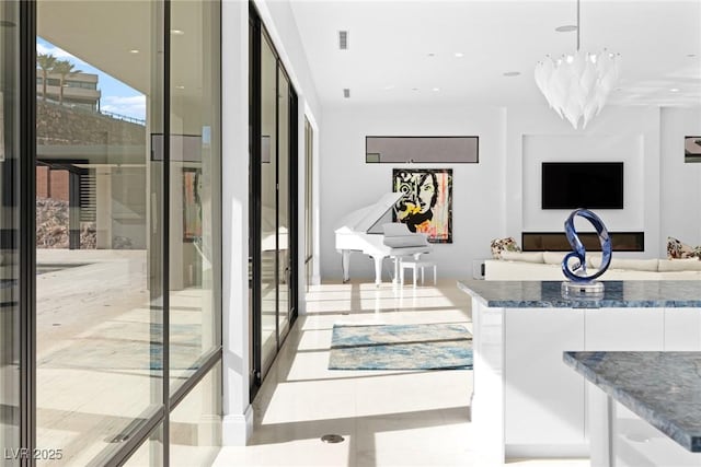 interior space featuring pendant lighting, visible vents, open floor plan, white cabinetry, and modern cabinets