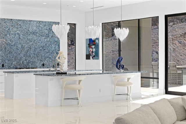 kitchen with white cabinets, modern cabinets, dark stone countertops, hanging light fixtures, and marble finish floor