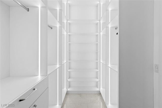 walk in closet with marble finish floor