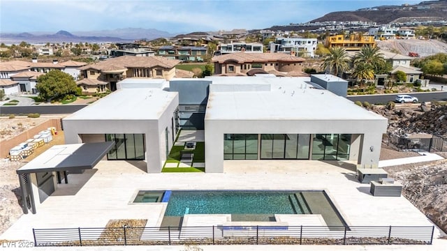 rear view of property featuring a residential view, a mountain view, a patio, and fence