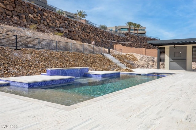 view of swimming pool with a hot tub, ceiling fan, stairway, and fence