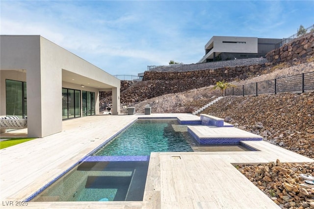 view of swimming pool featuring a patio, fence, a fenced in pool, and an in ground hot tub