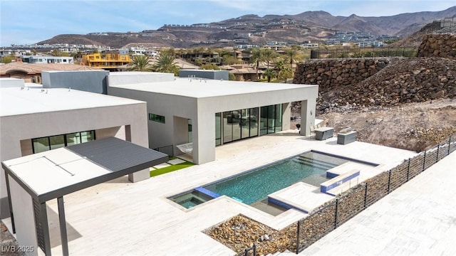 rear view of house featuring stucco siding, fence, a mountain view, and a patio