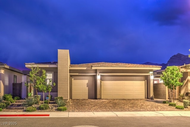 view of front of property featuring a garage and a mountain view