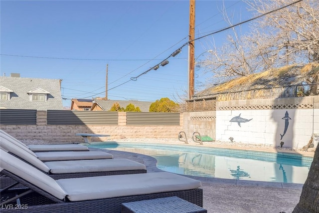 view of pool featuring a fenced in pool, a fenced backyard, and a diving board