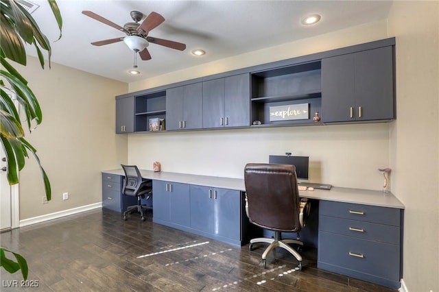 office space featuring dark wood-type flooring, ceiling fan, and built in desk