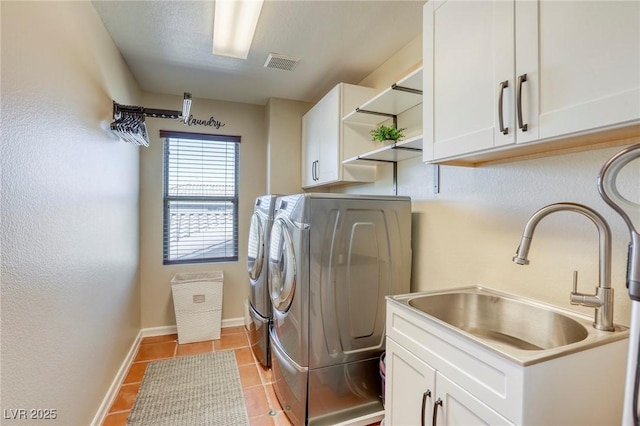 washroom featuring cabinets, light tile patterned flooring, sink, and independent washer and dryer