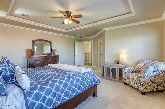 bedroom featuring crown molding, a tray ceiling, light colored carpet, and ceiling fan