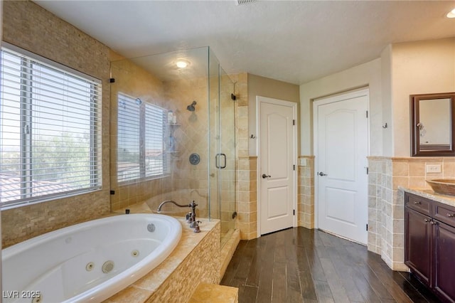 bathroom featuring hardwood / wood-style flooring, vanity, shower with separate bathtub, and tile walls