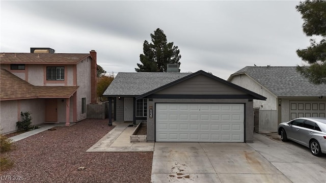 view of front of property featuring driveway, roof with shingles, and an attached garage