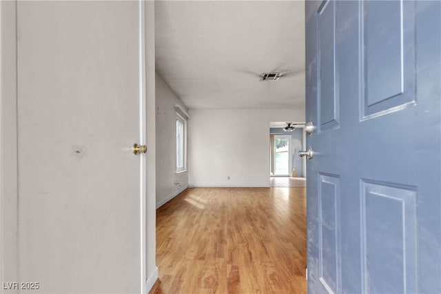 foyer featuring light wood-style floors, visible vents, and a textured ceiling