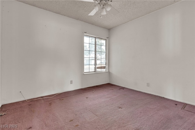 carpeted spare room featuring a textured ceiling and a ceiling fan