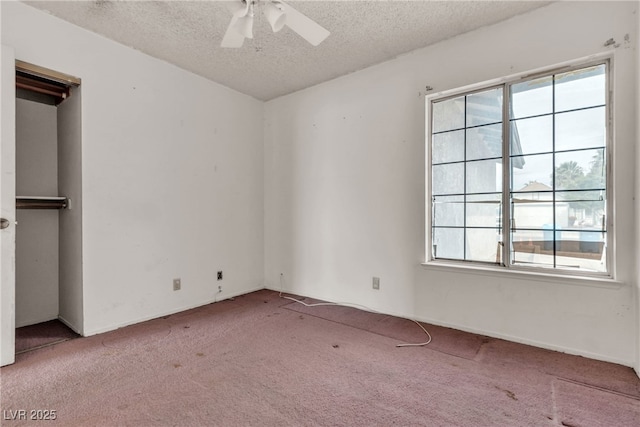 spare room with a textured ceiling, ceiling fan, and carpet flooring