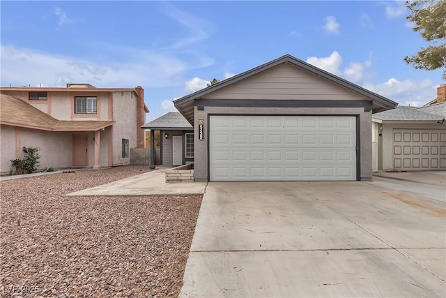 view of front of property with concrete driveway, roof with shingles, an attached garage, and stucco siding