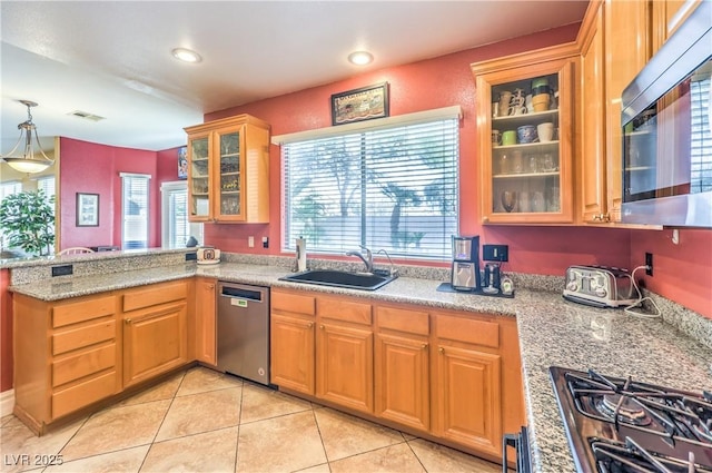 kitchen with visible vents, glass insert cabinets, hanging light fixtures, stainless steel appliances, and a sink