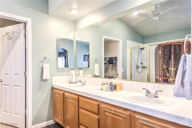 full bath featuring ceiling fan, a stall shower, a sink, and double vanity