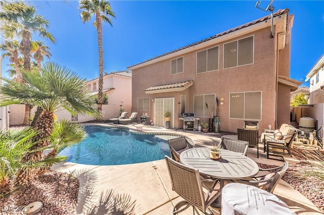 view of swimming pool featuring fence, area for grilling, a fenced in pool, and a patio