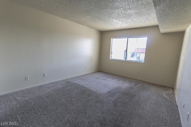 spare room featuring a textured ceiling and carpet