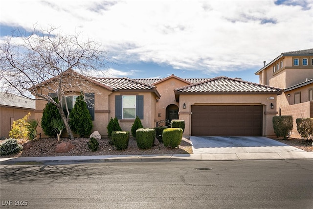 mediterranean / spanish home with a tile roof, an attached garage, driveway, and stucco siding