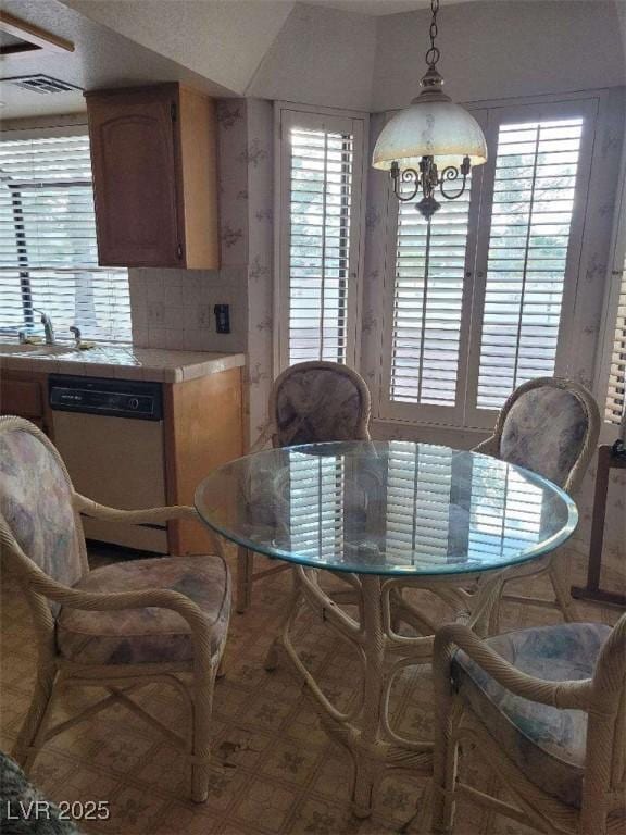 dining space with sink and a notable chandelier