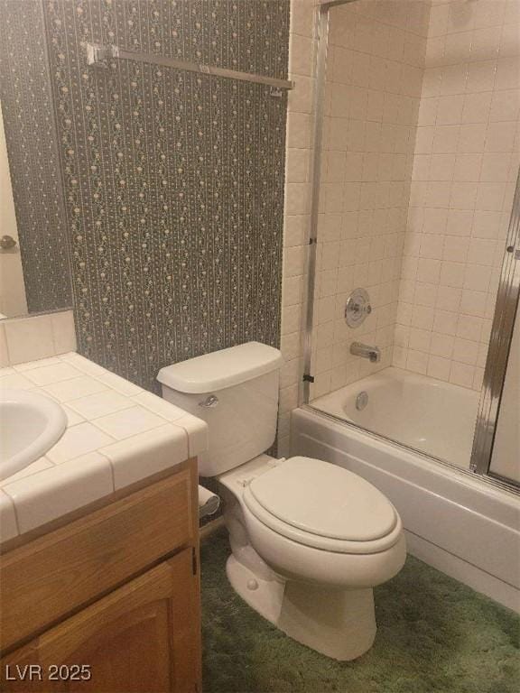 full bathroom featuring vanity, toilet, and combined bath / shower with glass door