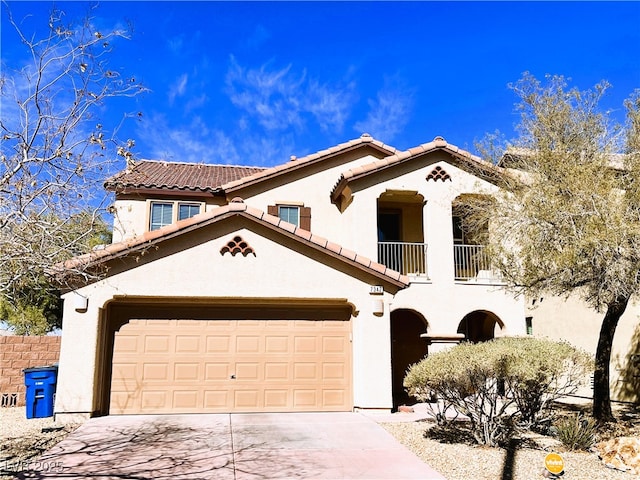 mediterranean / spanish-style home with a tile roof, stucco siding, concrete driveway, an attached garage, and a balcony