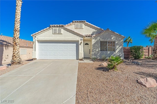 mediterranean / spanish-style house with driveway, a tiled roof, a garage, and stucco siding