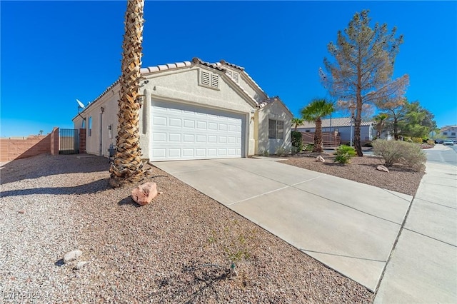 view of front of house with driveway, a tiled roof, an attached garage, fence, and stucco siding