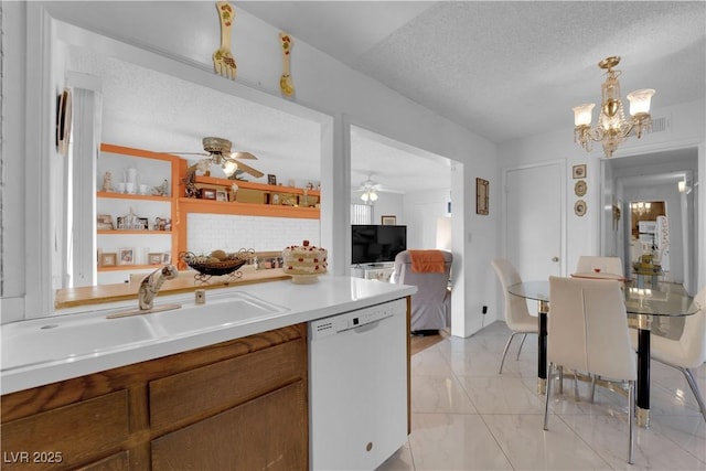 kitchen with decorative light fixtures, sink, dishwasher, a textured ceiling, and ceiling fan with notable chandelier