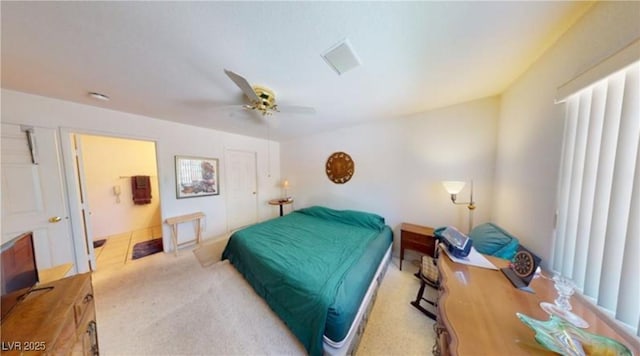 bedroom with light carpet, ensuite bath, and ceiling fan