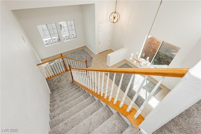 staircase with a notable chandelier