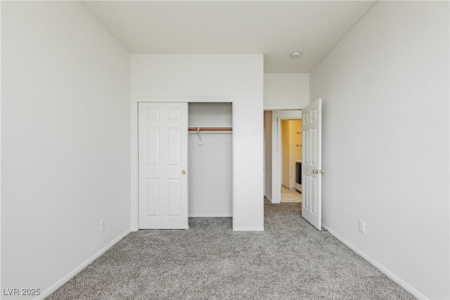 unfurnished bedroom featuring light colored carpet and a closet