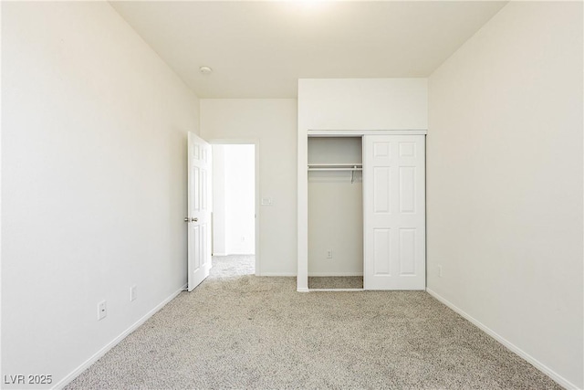 unfurnished bedroom with a closet and light carpet