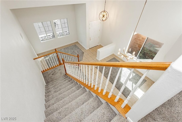 staircase with a chandelier and baseboards