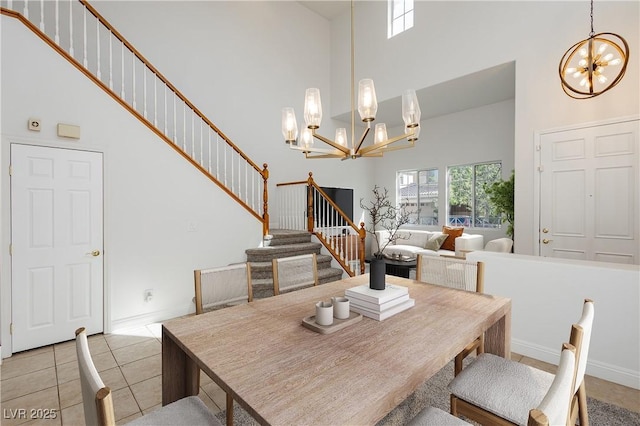 dining area with baseboards, a high ceiling, an inviting chandelier, stairway, and light tile patterned flooring