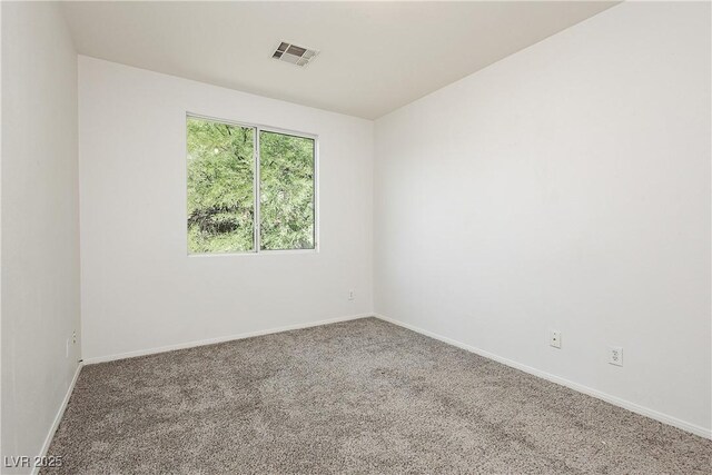 empty room featuring visible vents, baseboards, and carpet