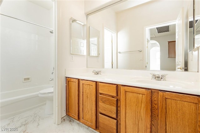 bathroom with bathing tub / shower combination, toilet, marble finish floor, a sink, and double vanity
