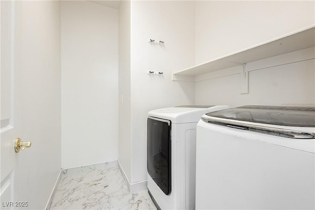 laundry room with laundry area, marble finish floor, washing machine and clothes dryer, and baseboards