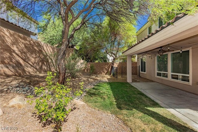 view of yard featuring a patio, a fenced backyard, and ceiling fan