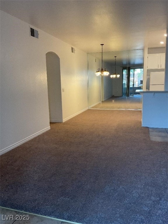 75 N Valle Verde Dr Unit 621, Henderson, NV 89074 - unfurnished living room featuring a chandelier, light colored carpet, baseboards, and arched walkways