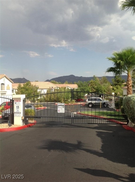 75 N Valle Verde Dr Unit 621, Henderson, NV 89074 - view of asphalt street featuring a gate, a mountain view, and a gated entry