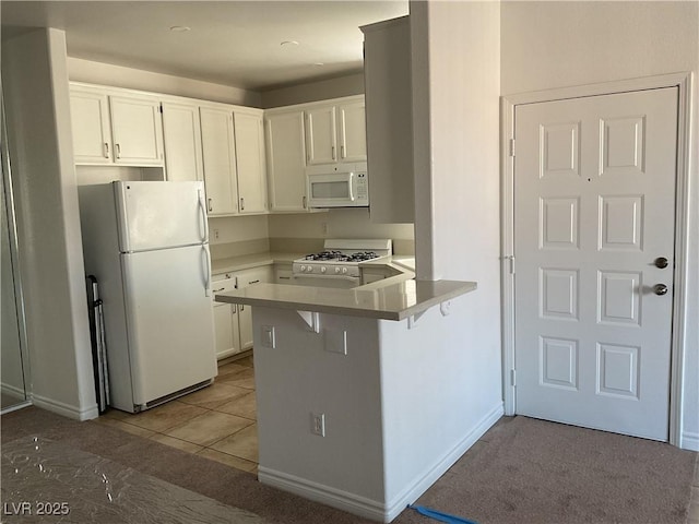 75 N Valle Verde Dr Unit 621, Henderson, NV 89074 - kitchen featuring white appliances, a peninsula, white cabinetry, light countertops, and a kitchen breakfast bar