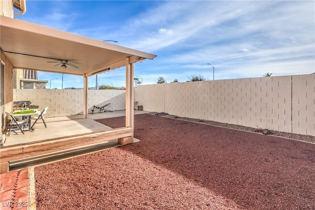 view of yard featuring ceiling fan and a patio area