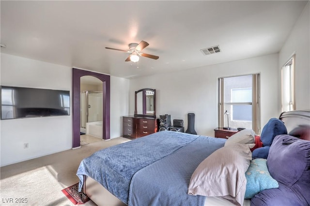 bedroom featuring connected bathroom, light colored carpet, and ceiling fan