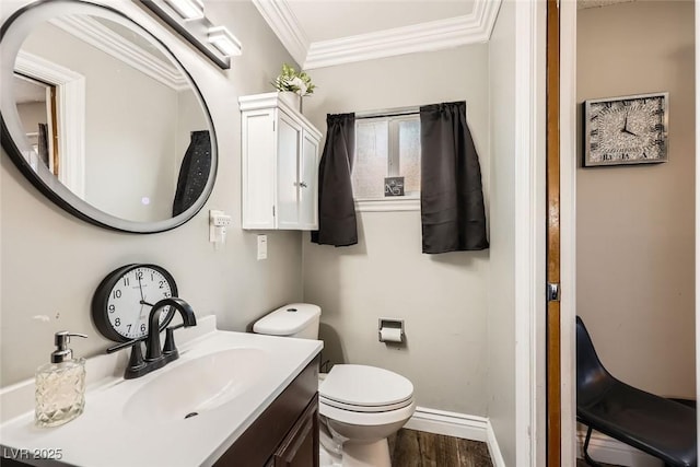 bathroom featuring toilet, ornamental molding, vanity, wood finished floors, and baseboards